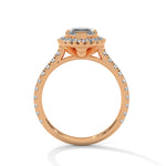 Rose gold ring with a large diamond and smaller diamonds on a white background 
